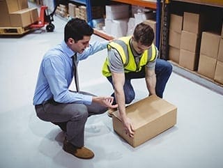 Safety Trainer teaching student how to lift box for manual handling course